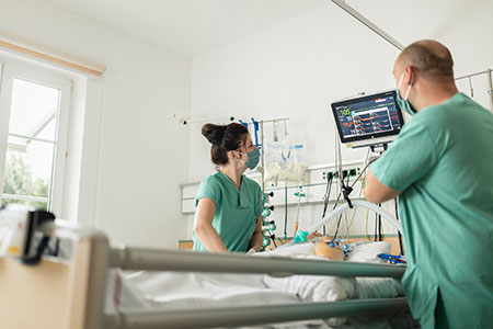 Pflegekräfte überwachen am Intensivbett die Vitalwerte eines Patientensimulators